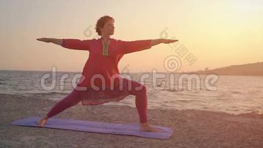 在海洋或海洋海滩上瑜伽。 瑜伽冥想的概念。 日落时分，女人在户外练习瑜伽